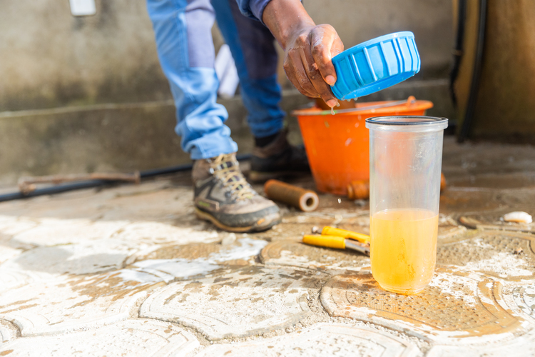 Plumber testing water quality during water damage restoration